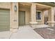 Inviting front porch with a dark green front door, side columns, and xeriscaping at 224 Pioneers Peak Ave, Henderson, NV 89002