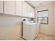 Laundry room featuring a side-by-side washer and dryer and ample cabinet space at 224 Pioneers Peak Ave, Henderson, NV 89002