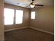 Cozy bedroom with plush carpet, multiple windows, and a ceiling fan at 2381 Lilac Cove St, Las Vegas, NV 89135