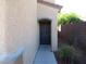 An entryway featuring a dark front door with stone trim, situated next to a side yard at 2381 Lilac Cove St, Las Vegas, NV 89135