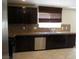 Modern kitchen featuring stainless steel appliances, dark cabinets, and tile flooring at 2381 Lilac Cove St, Las Vegas, NV 89135