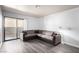This living room features gray wood-look flooring, a neutral sectional couch, and sliding glass door to a patio at 2451 N Rainbow Blvd # 1016, Las Vegas, NV 89108