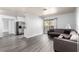 Bright living room boasts gray wood-look flooring, a neutral sectional couch, and sliding glass door to a patio at 2451 N Rainbow Blvd # 1016, Las Vegas, NV 89108
