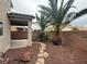 A private backyard with a stone path, desert landscaping, and covered patio area at 258 Bella Matese Ave, Las Vegas, NV 89183