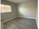 Small, simple bedroom with neutral walls, gray floors, and a single window with a shade at 258 Bella Matese Ave, Las Vegas, NV 89183