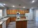 Well-lit kitchen with an island, wooden cabinets, gray countertops and flooring, and white appliances at 258 Bella Matese Ave, Las Vegas, NV 89183