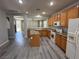 Well-lit kitchen with an island, wooden cabinets, gray countertops and flooring, and white appliances at 258 Bella Matese Ave, Las Vegas, NV 89183