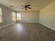Spacious living room with gray flooring, a ceiling fan, and large windows providing natural light at 258 Bella Matese Ave, Las Vegas, NV 89183