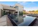 Backyard featuring a modern pool, comfortable lounge chairs, and a view of the home's unique architecture at 2655 Juniper Branch St, Las Vegas, NV 89117
