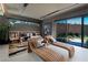 Modern bedroom with lounge chairs, a king bed, and sliding doors to backyard at 2655 Juniper Branch St, Las Vegas, NV 89117