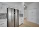 Bright kitchen with stainless steel refrigerator, white cabinetry, and mosaic backsplash at 2721 Faiss Dr, Las Vegas, NV 89134