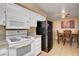 The kitchen features white appliances, white cabinetry, and access to the dining area at 2725 S Nellis Blvd # 1052, Las Vegas, NV 89121