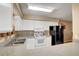 Well-lit kitchen featuring white cabinetry, a stainless steel sink, and black refrigerator at 2725 S Nellis Blvd # 1052, Las Vegas, NV 89121