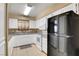The kitchen includes white appliances, white cabinetry, tile floors, and black refrigerator at 2725 S Nellis Blvd # 1052, Las Vegas, NV 89121