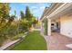 Beautiful backyard featuring a lush lawn, paved patio, outdoor fireplace, and serene pool area at 28 Tea Olive Dr, Las Vegas, NV 89141