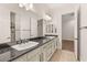 Bathroom offers dual sinks with dark countertops, ample cabinet storage, and a shower in the background at 28 Tea Olive Dr, Las Vegas, NV 89141
