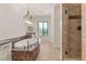 Bright bathroom showcases a soaking tub with chandelier, plus walk-in shower with glass door at 28 Tea Olive Dr, Las Vegas, NV 89141
