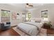 Staged bedroom features a comfortable bed, hardwood floors, and three large windows at 28 Tea Olive Dr, Las Vegas, NV 89141