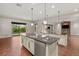 Kitchen with island, stainless steel sink, granite countertops and wood floors at 28 Tea Olive Dr, Las Vegas, NV 89141