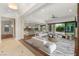 Spacious living room is virtually staged, showcasing hardwood floors and an open layout with access to the kitchen and patio at 28 Tea Olive Dr, Las Vegas, NV 89141