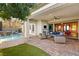 Inviting covered patio with comfortable seating, fireplace, and views of the pool and waterfall at 28 Tea Olive Dr, Las Vegas, NV 89141