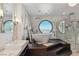 Luxurious bathroom with soaking tub, marble accents, sleek fixtures, and a round window offering city views at 2857 Paradise Rd # 2203, Las Vegas, NV 89109
