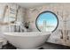 Elegant bathtub beneath a round window offering a captivating city view with upscale marble accents at 2857 Paradise Rd # 2203, Las Vegas, NV 89109