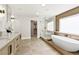 Luxurious bathroom showcasing a soaking tub, a walk-in shower, and elegant tile flooring at 2937 Billy Casper Dr, Las Vegas, NV 89134