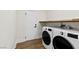 Functional laundry room equipped with modern washer and dryer units and storage shelf at 2937 Billy Casper Dr, Las Vegas, NV 89134