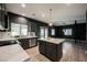 Open floor plan showcases kitchen with island, stainless steel appliances, and living space with a modern chandelier at 3409 Catherine Mermet Ave, North Las Vegas, NV 89081