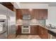 Modern kitchen with stainless steel appliances, granite countertops, and dark wood cabinets at 353 E Bonneville Ave # 181/281, Las Vegas, NV 89101