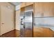 Kitchen area features stainless steel refrigerator, wood cabinets, and gray granite countertops at 353 E Bonneville Ave # 503, Las Vegas, NV 89101
