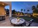 Outdoor patio with table overlooking a custom pool with rock waterfall and swim up bar at 382 Chaplin Cove Ave, Las Vegas, NV 89183