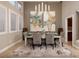 Dining room with a long table, modern chandelier, neutral decor, and bright natural light at 382 Chaplin Cove Ave, Las Vegas, NV 89183