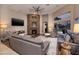 Bright living room with a stone fireplace, comfortable seating, and modern ceiling fan at 382 Chaplin Cove Ave, Las Vegas, NV 89183