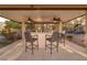 Outdoor covered bar area featuring ample seating, ceiling fans, and views of backyard and play area at 382 Chaplin Cove Ave, Las Vegas, NV 89183