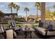 Inviting outdoor patio with comfortable seating overlooking a lush backyard, pool, and waterfall feature at 382 Chaplin Cove Ave, Las Vegas, NV 89183