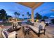 Covered outdoor patio with plush seating, a dining table, and views of the stunning pool area at 382 Chaplin Cove Ave, Las Vegas, NV 89183