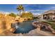 Backyard oasis with a gorgeous rock waterfall, large pool, and sunken fire pit at 382 Chaplin Cove Ave, Las Vegas, NV 89183