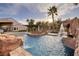 Resort-style pool with rock waterfall feature, spa, and covered outdoor bar, creating a luxurious retreat at 382 Chaplin Cove Ave, Las Vegas, NV 89183