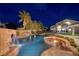 Custom pool with rock waterfall, spa, and fire pit with views of home at twilight at 382 Chaplin Cove Ave, Las Vegas, NV 89183