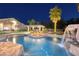 Custom pool with rock waterfall, spa, and swim up bar, all illuminated at twilight at 382 Chaplin Cove Ave, Las Vegas, NV 89183