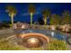 Custom pool with rock waterfall, spa, and fire pit all illuminated at twilight at 382 Chaplin Cove Ave, Las Vegas, NV 89183