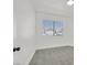 Sunlit bedroom with white walls and neutral carpet and a street view from the window at 4137 Buffalo Bill Ave, Las Vegas, NV 89110