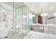 Bright, modern bathroom featuring marble walls, a glass-enclosed shower, and sleek fixtures at 4381 W Flamingo Rd # 57306, Las Vegas, NV 89103