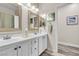 Well-lit bathroom featuring dual sinks, white cabinetry, and a decorative mirror at 4624 Ventana Rey St, North Las Vegas, NV 89081