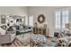 This living room offers wood floors, neutral decor, lots of natural light, and stylish furniture at 4624 Ventana Rey St, North Las Vegas, NV 89081