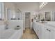 Bright main bathroom with dual sinks, a separate shower, and a bathtub for relaxation at 4624 Ventana Rey St, North Las Vegas, NV 89081