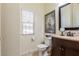 Bathroom with a white toilet, dark cabinets, and large window with natural light at 4808 Straight Flush Dr # 103, Las Vegas, NV 89122