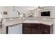 Open kitchen with white dishwasher, sink, and dark wood cabinets under a bar top at 4808 Straight Flush Dr # 103, Las Vegas, NV 89122